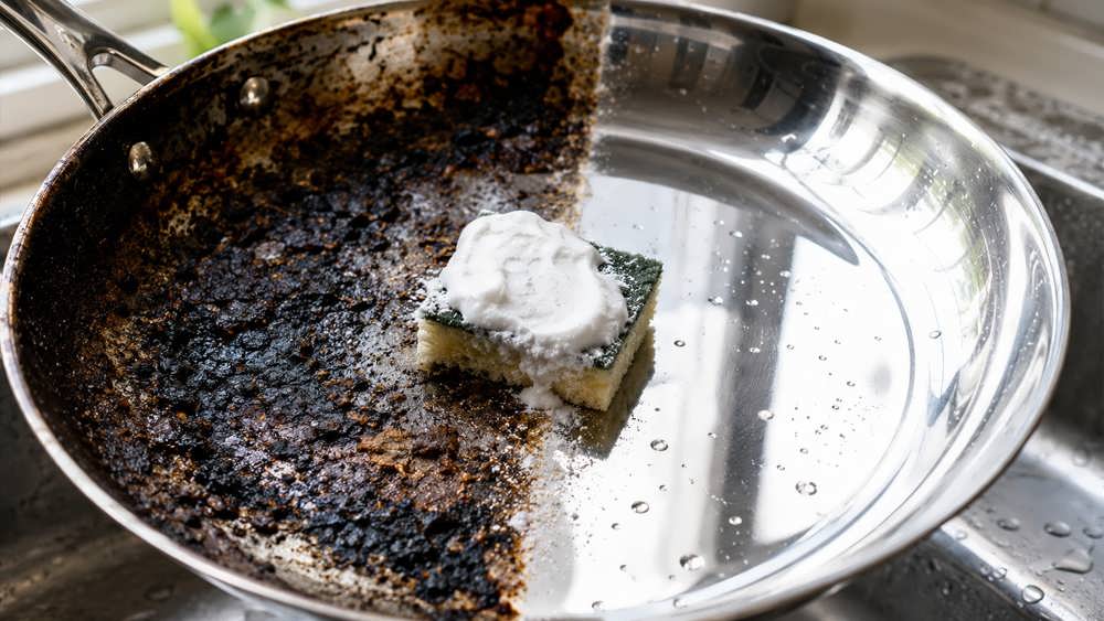 سابیدن و تمیز کردن کف یک قابلمه فلزی با سیم ظرفشویی و جوش شیرین تا حد براق شدن