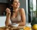 چیدمان رنگارنگ ماهی سالمون، گردو، تخم‌مرغ، موز و سبزیجات تازه روی میز چوبی