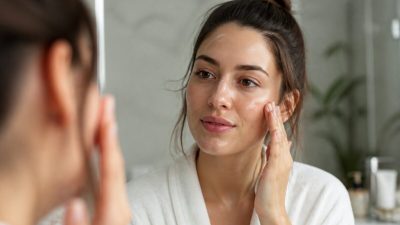 نمای نزدیک از چهره زنی با پیشانی و بینی براق و گونه‌های مات در نور طبیعی