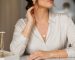 نمای نزدیک از زنی با گوشواره‌های طلایی ظریف و گردنبند لایه‌ای مینیمال در نور طبیعی