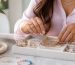 نمای نزدیک از گردنبندهای لایه‌ای طلایی و نقره‌ای با مهره‌های رنگی روی لباس روشن