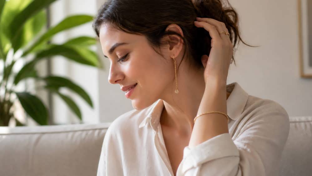 زن با استایل شب لوکس و گوشواره‌های آویز بلند با سنگ‌های قیمتی بنفش