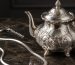 مجموعه‌ای از ظروف و جواهرات نقره استرلینگ لوکس روی میز مرمر تیره