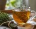فنجان دمنوش آویشن با شاخه‌های تازه آویشن و عسل روی میز چوبی روشن