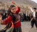 گروهی از مردم با لباس‌های محلی در حال اجرای موسیقی و رقص سنتی در فضای باز