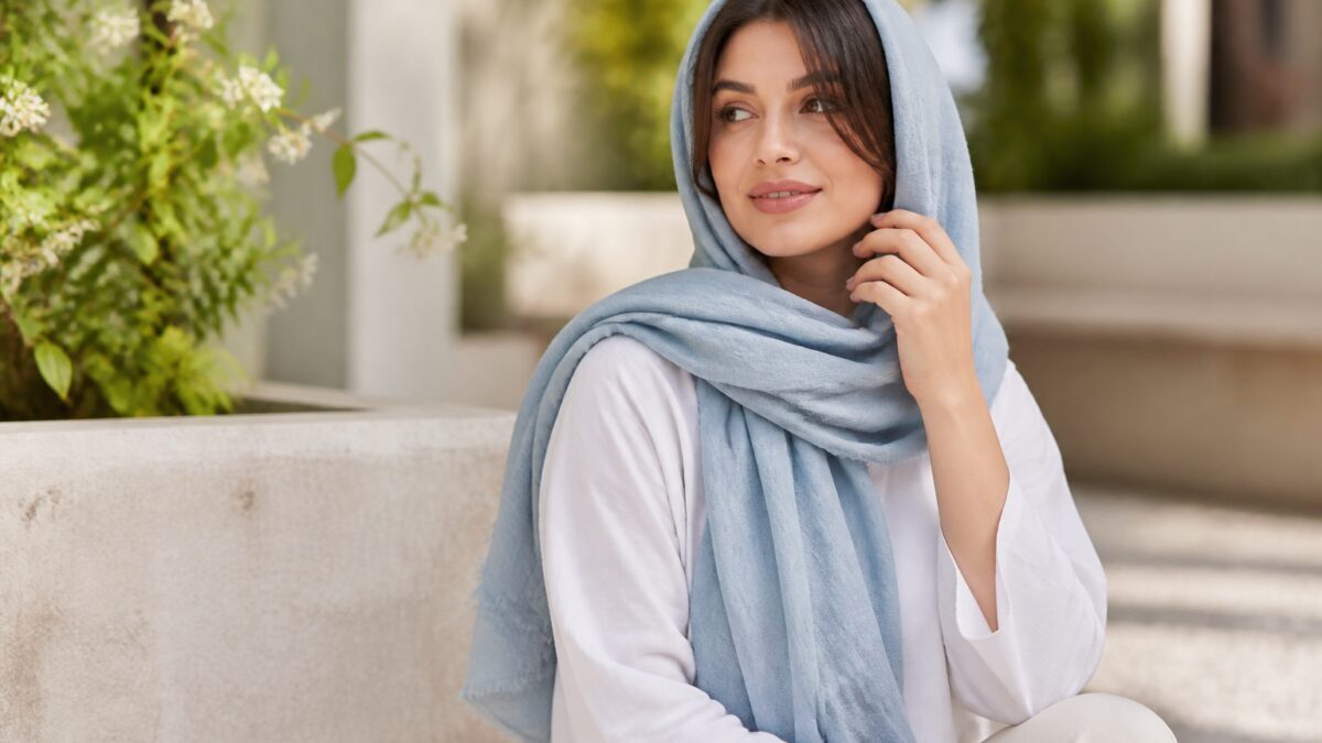 شال نخی روشن با بافت نرم و سبک، آویخته روی صندلی چوبی در نور طبیعی
