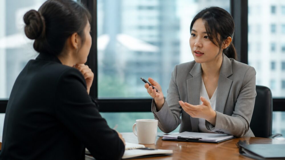 دو همکار در جلسه کاری با واکنش های متفاوت به سخن یک مدیر؛ یکی آرام و دیگری ناراحت